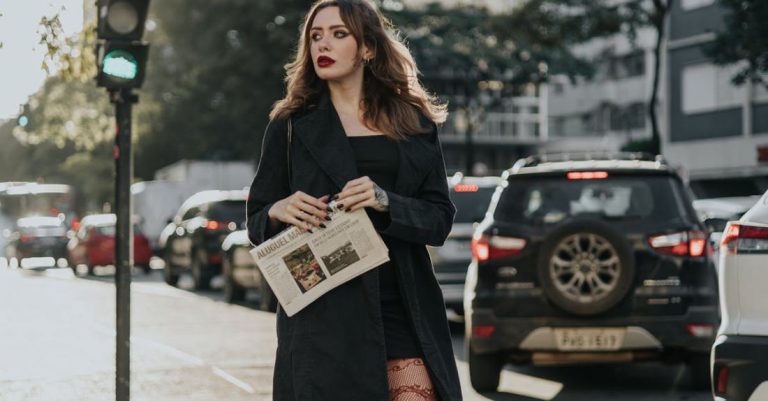 Walks - A woman in tights and a black coat is crossing the street